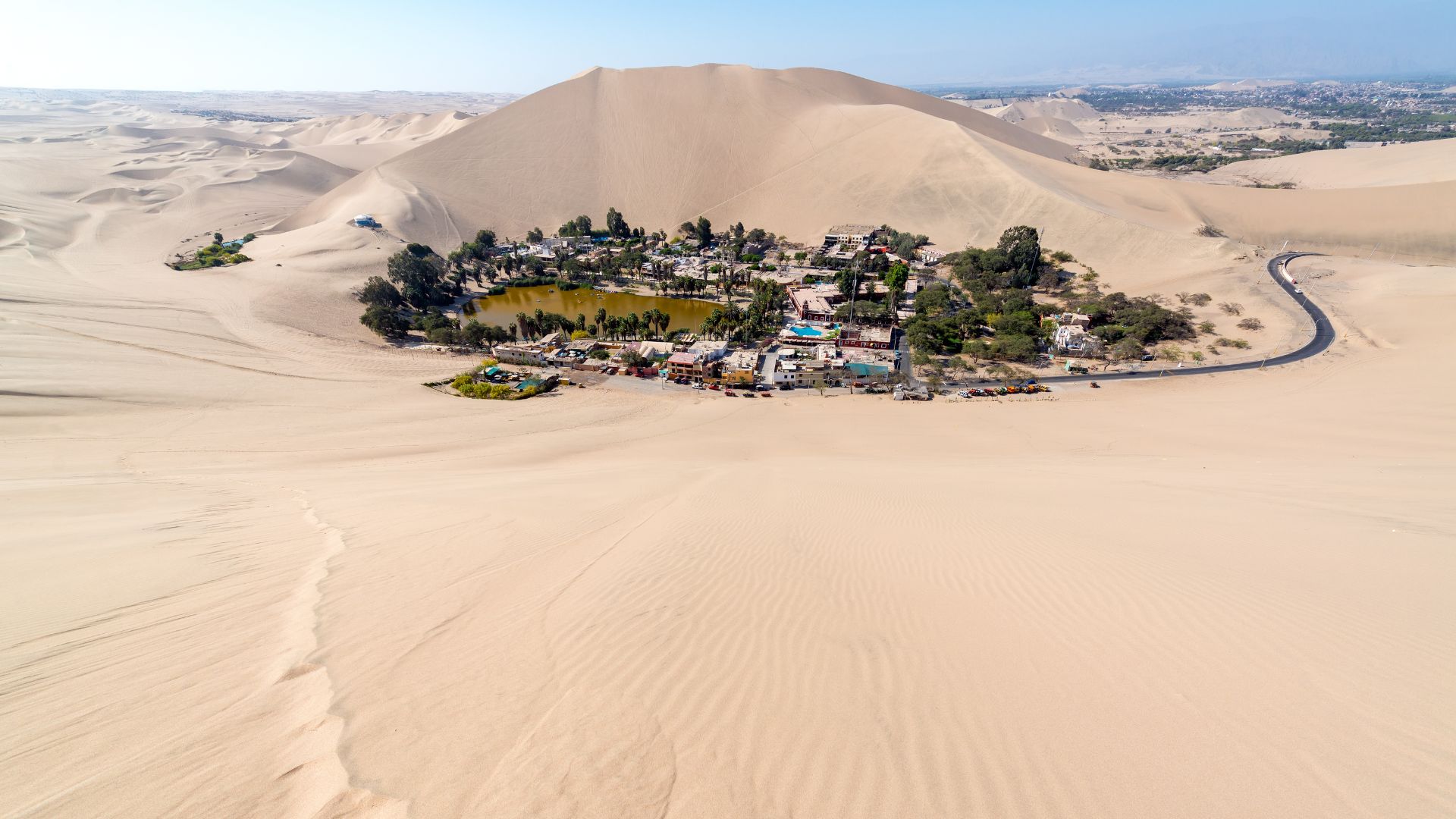 Huacachina pálmafákkal körülvett sivatagi oázisa Peruban